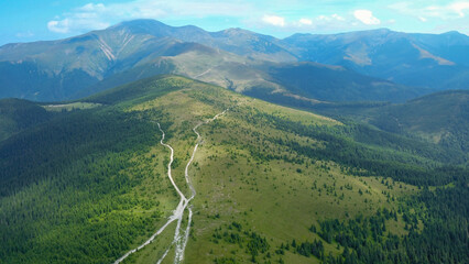 Aerial drone view over the green alpine grasslands of Parang Massif. The summits are surrounded by...