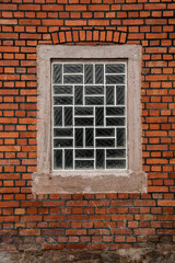 Glass brick window on old red brick wall, vertical format