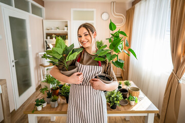 One woman young caucasian female stand at home hold flower plants pot