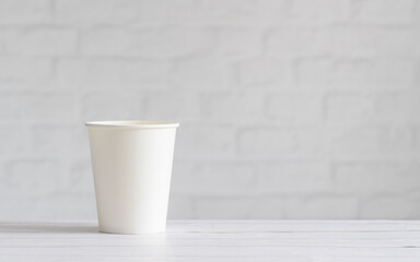 White paper cup on the background of the wall. Eco-friendly tableware. Template, copy space. Zero waste concept