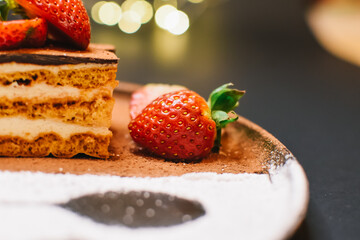Chocolate cake with Strawberry. Sprinkled powder decoration on the plate