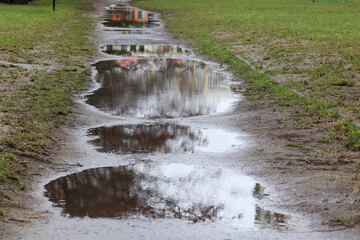 Kałuże wody po deszczu na drodze i chodniku. © DarSzach