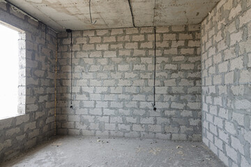 Construction of an individual residential building, a view of the expanded clay concrete wall without finishing, electric wires are laid