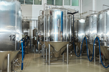 Steel fermentation tanks in workshop at industrial factory
