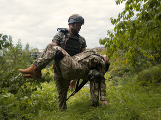 The commander carries a wounded soldier