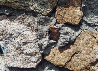 Large old stones with exposed cement. Wall texture.