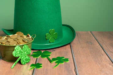 Celebrating St. Patrick's Day with a touch of luck: green hat, shamrocks and coins on a wooden table. High quality photo