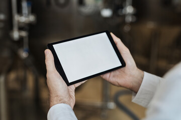 Close up of male hands holding digital tablet at food factory workshop