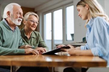 Happy senior couple having a meeting with their insurance agent at home