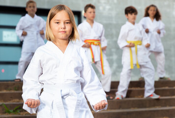 Fototapeta na wymiar Little girl throws a punch at martial arts practice