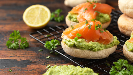 Fresh English Muffins with avocado and salmon. Healthy morning breakfast food