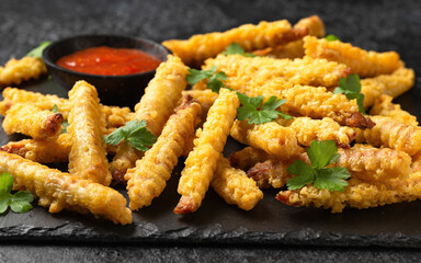 Fried Vegan jackfruit and oyster prawns in crispy batter served on black slate with chili dip sauce