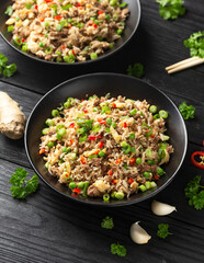 Asian Beef Fried Rice with eggs and vegetables in black bowl