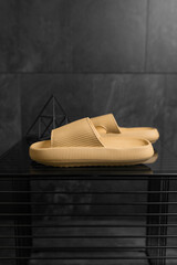 Mustard color Sandals shoes. Beige flip flops on dark black background.