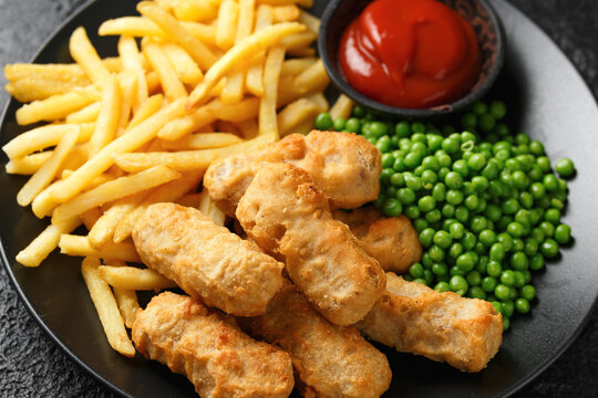 Irish battered sausages with potato fries, green peas and ketchup