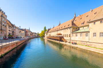 Historic buildings along the Ill River near Pont du Corbeau Bridge in the downtown district near the old town of Strasbourg, France.