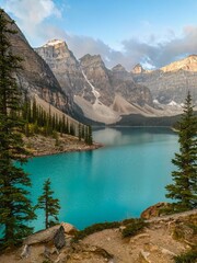 Looking towards mountains of Valley of the Ten Peaks early on an autumn morning with a view across the blue-green waters of Moraine Lake in Louise, AB, Canada.