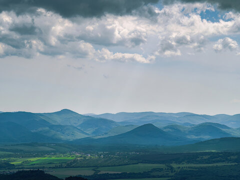Countryside landscape with hills forest village cloudy sky