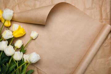 Beautiful postcard with space for copy, tulips white and yellow. Spring blooming tulips on a beige craft background with a curved corner. Packaging paper with delicate colors. Mother's Day, March 8