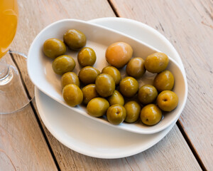 Typical Spanish tapas - appetizing pickled green olives with a stone