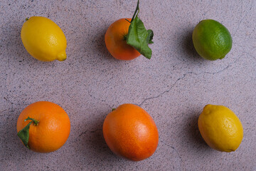 Overhead view of citrus fruits, oranges, lemons, tangerines, lime on stone background