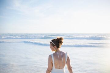 Fototapeta na wymiar happy elegant female in white beachwear at beach relaxing