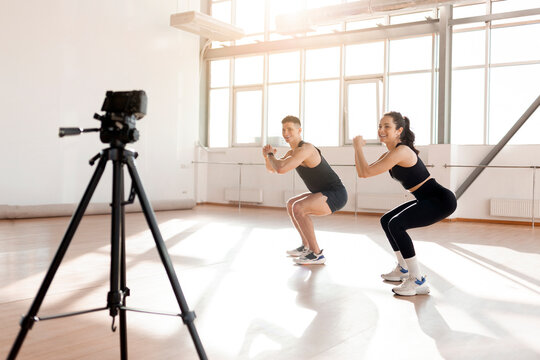 young athletic couple of bloggers in sportswear stream online workout on camera, man and woman go in for sports