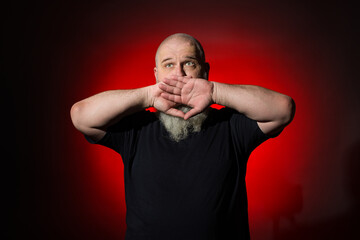 The gray-haired man covered his mouth with his palms and does not want to say anything or the...