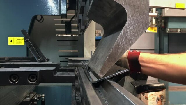 Bending of sheet metal parts using a sheet metal bending machine in factory. Metallurgical industry