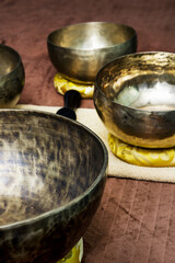 large Tibetan metal containers for the ritual of relaxing massage on a table with towels, cloths and similar objects