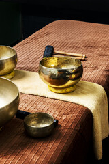 Tibetan metal bowls for the ritual of relaxing massages on a table with towels