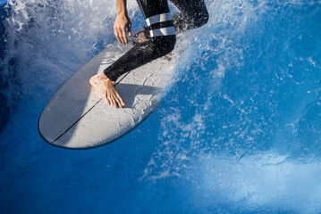 A surfer looking for traction on his board on the crest of the wave