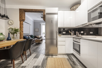 kitchen open to dining room in a room of a vintage building with restored wooden structure