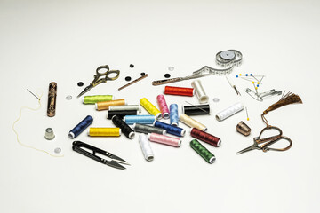 Sewing still life with spools of colored threads on white background