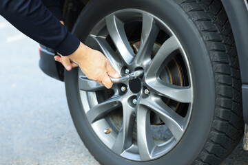 Man changing tire of car outdoors, closeup