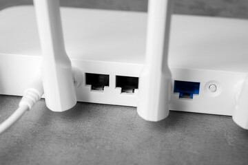 New modern Wi-Fi router on grey table, closeup