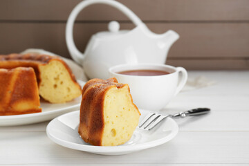 Piece of delicious homemade yogurt cake served on white wooden table