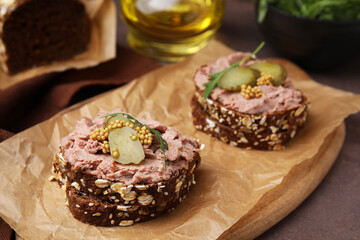 Delicious liverwurst sandwiches with pickled cucumber and mustard on grey table, closeup
