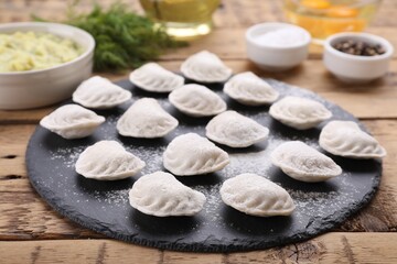 Fototapeta na wymiar Raw dumplings (varenyky) and ingredients on wooden table