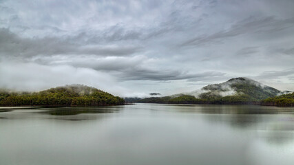 Moody sky over lake and misty hills