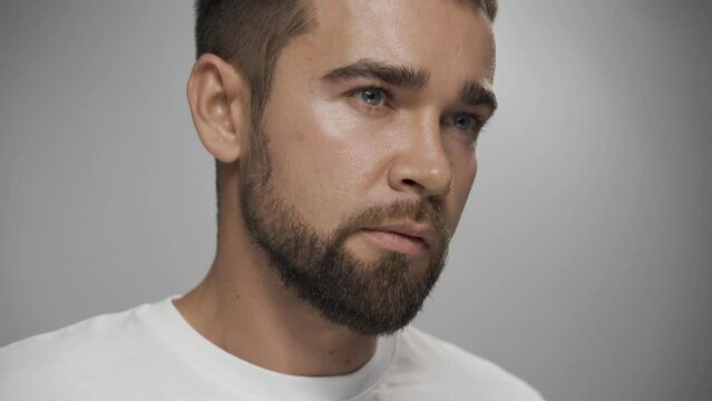 Handsome bearded man with clean skin against gray background