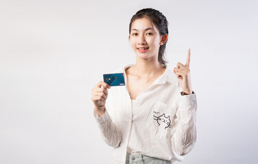 Young beautiful Asian woman smiling, showing, presenting credit card for making payment or paying online business, Pay a merchant or as a cash advance for goods, Cardholder or A person who owns a card