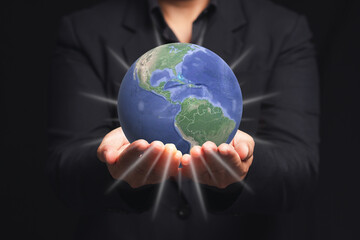 The Earth on the palm businessman while standing on a black background