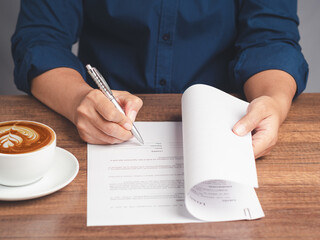Signature concept. Businessman signing a contract or agreement while sitting at the table in the...