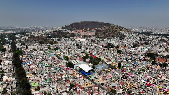 Ghetto neighborhood and a old volcano crater, in sunny Iztapalapa, Mexico - Aerial view