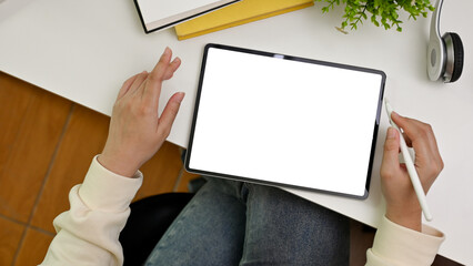 Top view workspace with a female using stylus pen and tablet. tablet white screen mockup