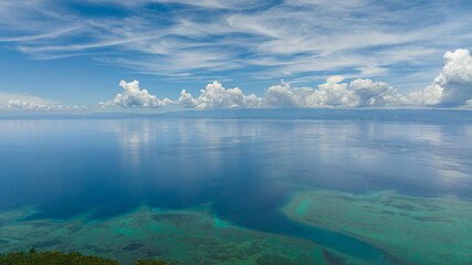 Aerial drone of the island of Cebu from the sea. Blue ocean and sky with clouds. Seascape in the tropics.
