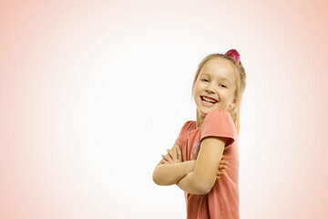 Funny happy little girl on pink background.