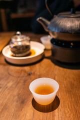 Cup of Chinese tea and teapot on a wooden table close-up view - 573397296