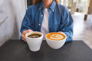Closeup image of a woman holding and serving two cups of hot coffee